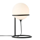 En bordslampa Wilson med rund opalvit glaskupa monterad p� svart metallst�ll st�r p� ett sidobord med spegelyta, medan produktinformation visas p� en webbsida; modellen s�ljs hos Elbutik.se f�r modern inomhusbelysning.