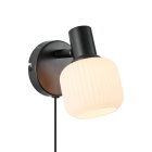 En v�ggmonterad lampa med svart f�ste och rund opalglaskupa riktar ljuset snett ned�t och skapar en mjuk belysning. Hos Elbutik.se finns denna kompakta armatur som passar perfekt vid s�ng eller l�sh�rna.