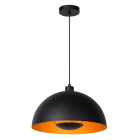 En svart pendellampa med kupad metallsk�rm h�nger fr�n taket mot vit bakgrund, d�r insidan av sk�rmen reflekterar ett varmt ljus. Elbutik.se presenterar modellen som en stilren l�sning f�r riktad belysning �ver bord eller k�ksytor.