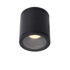 En svart cylindrisk takspotlight monteras utanp� taket och riktar ett koncentrerat ljus ned�t, vilket ger tydlig punktbelysning, en robust och stilren l�sning fr�n Elbutik.se f�r badrumsmilj�er.