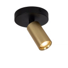 En takmonterad spotlight med svart bas och m�ssingsf�rgad cylindrisk ljusk�lla riktar ljuset ned�t, vilket ger en varm och fokuserad belysning, en elegant l�sning som Elbutik.se erbjuder f�r moderna interi�rer.