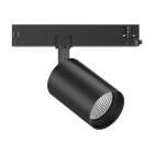 En svart skenspotlight monterad p� trefasskena visas i vinkel d�r det riktbara lamphuvudet m�jligg�r exakt ljuss�ttning av butik eller galleri, en flexibel belysningsl�sning som erbjuds av Elbutik.se.