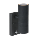 En svart Arne LED V�gglampa Dubbel Sensor visas mot vit bakgrund med cylindrisk armatur och integrerad r�relsesensor. Elbutik.se erbjuder modellen f�r energieffektiv fasadbelysning med ljus upp�t och ned�t.