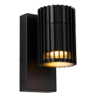 En svart v�gglampa med cylindrisk form och vertikala ribbor �r monterad p� ett rektangul�rt v�ggf�ste mot vit bakgrund. Elbutik.se erbjuder armaturen f�r stilren och funktionell utomhusbelysning med GU10-ljusk�lla.