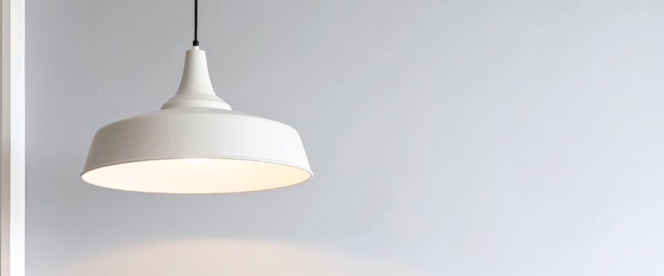 Vit pendellampa t&auml;nd mot ljus v&auml;gg i stilren inomhusmilj&ouml;, d&auml;r Elbutik.se visar en vanlig typ av armatur som ansluts via lamputtag i taket.