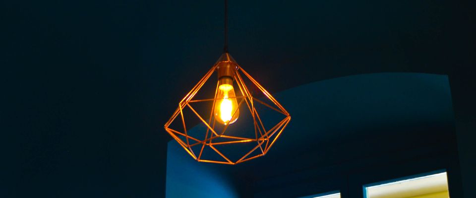 Pendellampa framf&ouml;r f&ouml;nster i varm kv&auml;llssol, d&auml;r Elbutik.se visar en typisk takarmatur i hemmilj&ouml; som g&ouml;r valet av r&auml;tt lamputtag och anslutning relevant.