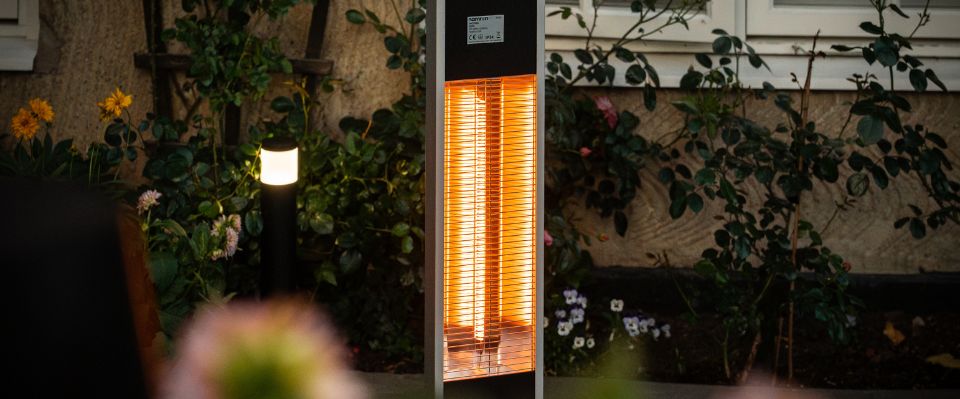 Golvst&aring;ende terrassv&auml;rmare intill loungegrupp under tak p&aring; uteplats, d&auml;r Elbutik.se visar en flexibel l&ouml;sning f&ouml;r riktad v&auml;rme i en skyddad och ombonad kv&auml;llsmilj&ouml;.