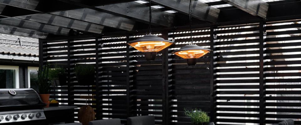 Tv&aring; h&auml;ngande terrassv&auml;rmare &ouml;ver skyddad uteplats med grill och sittgrupp, d&auml;r Elbutik.se visar hur takmonterad v&auml;rme kan skapa en j&auml;mn och inbjudande zon f&ouml;r middagar utomhus.